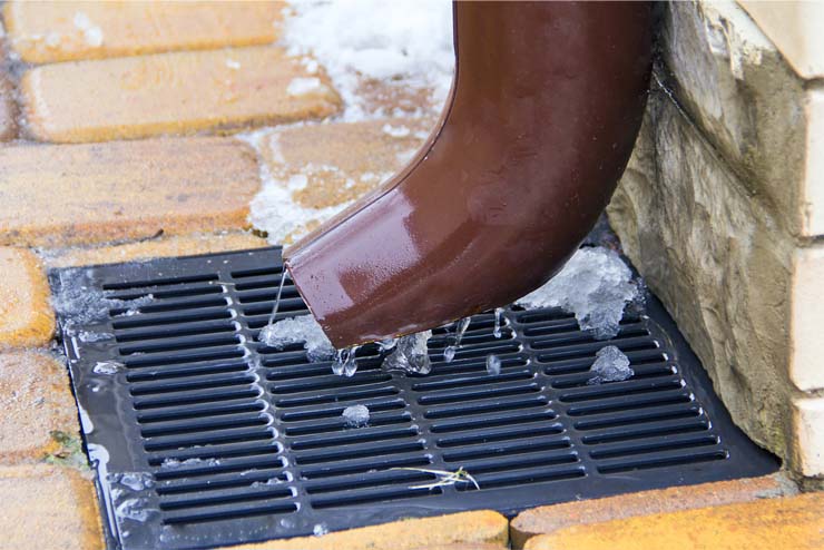 An exterior frozen drainage pipe.