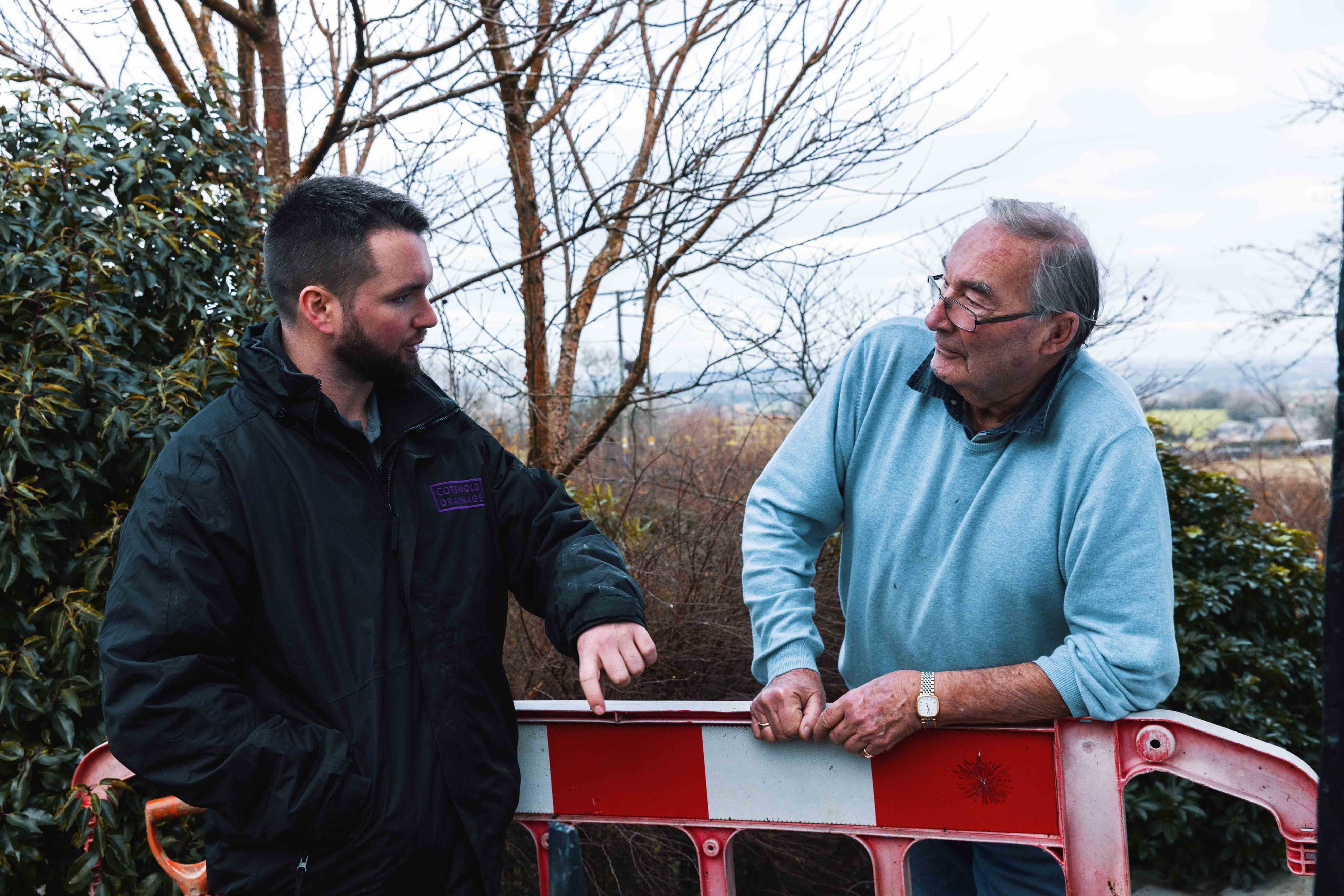 Cotswold drainage engineer in conversation with a customer