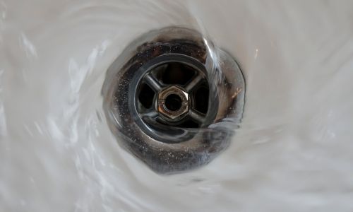 example of sink plug with water going through it into a drain