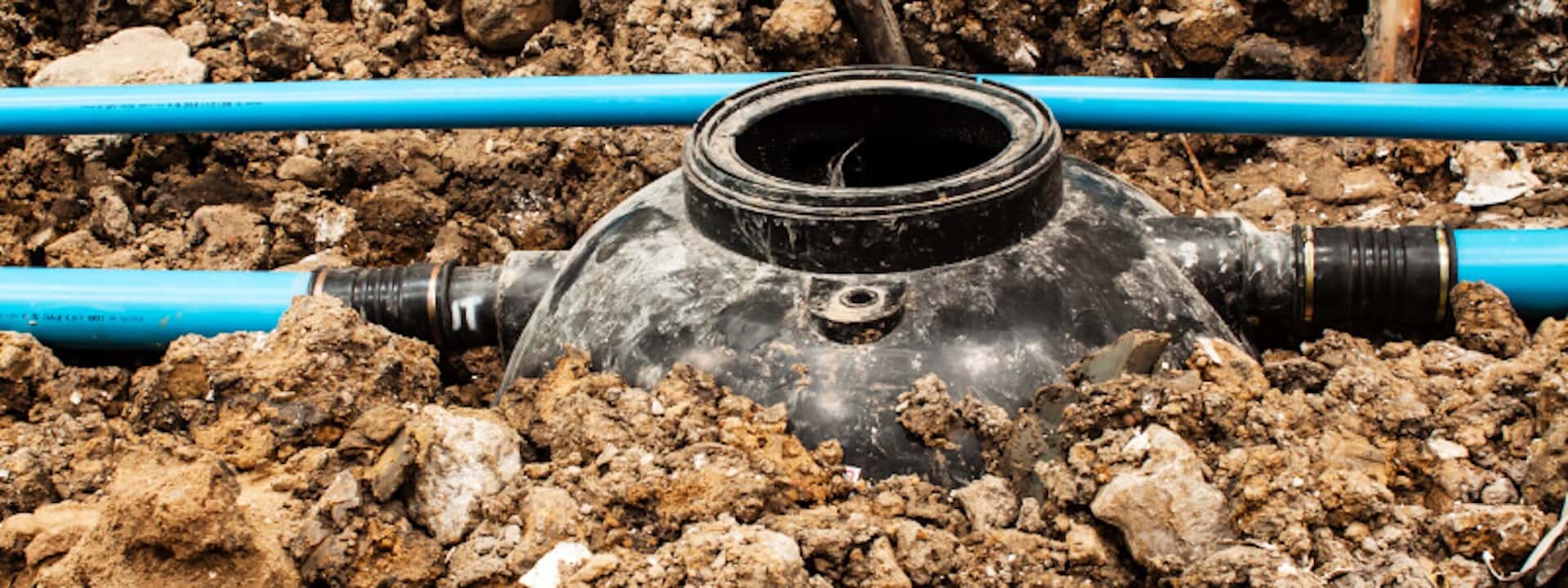 Septic tank in the ground, connected to pipes.
