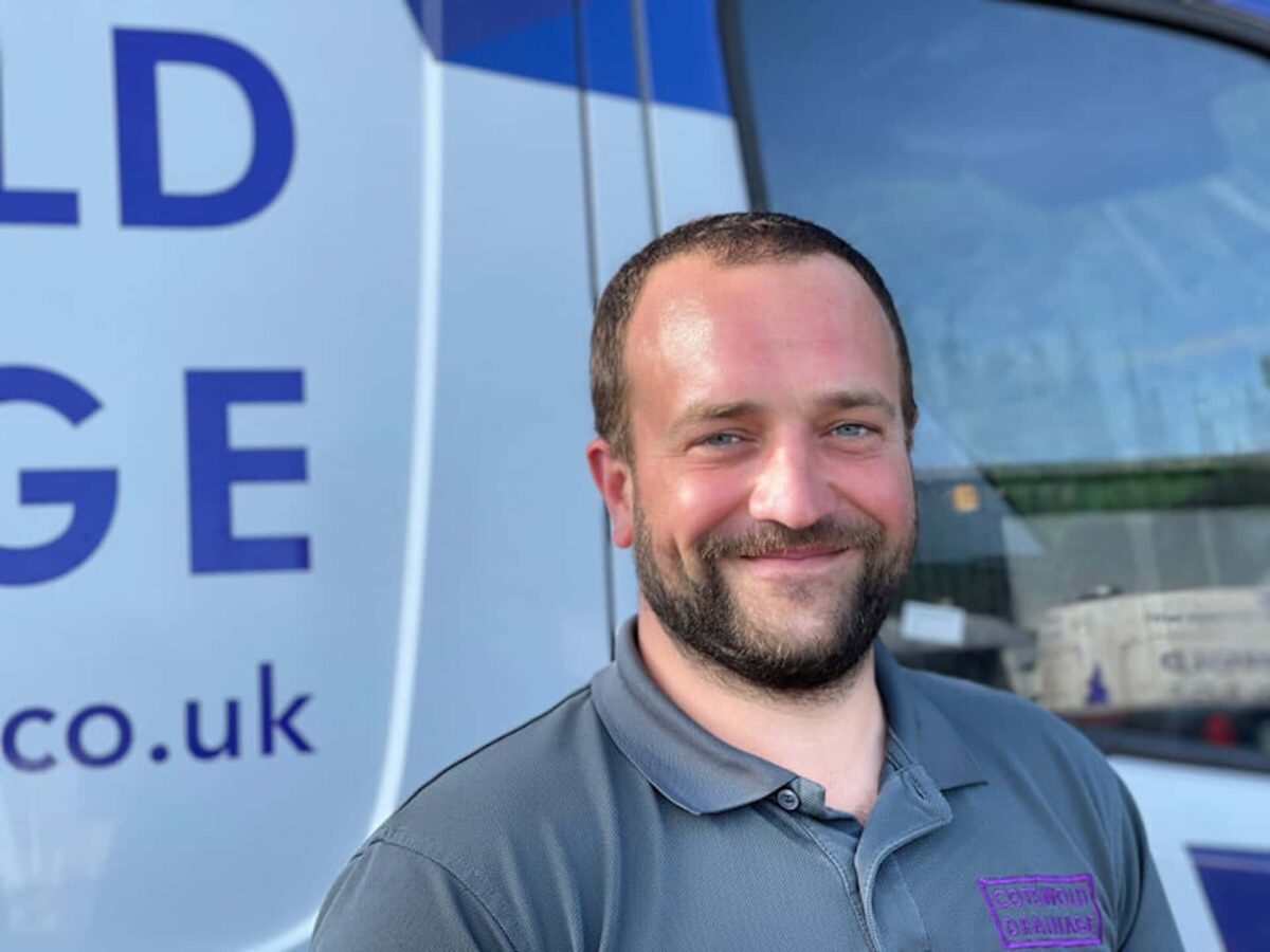 Mark smiling next to a Cotswold Drainage van